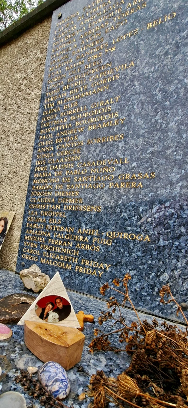 Ovale Aluminium-Fotoplatte mit Paar und weißem Hund vor einer Gedenkwand aus blauem Granit